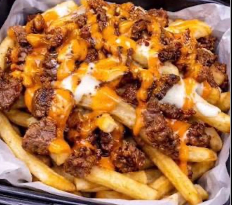 Philly cheesesteak loaded fries drizzled with queso