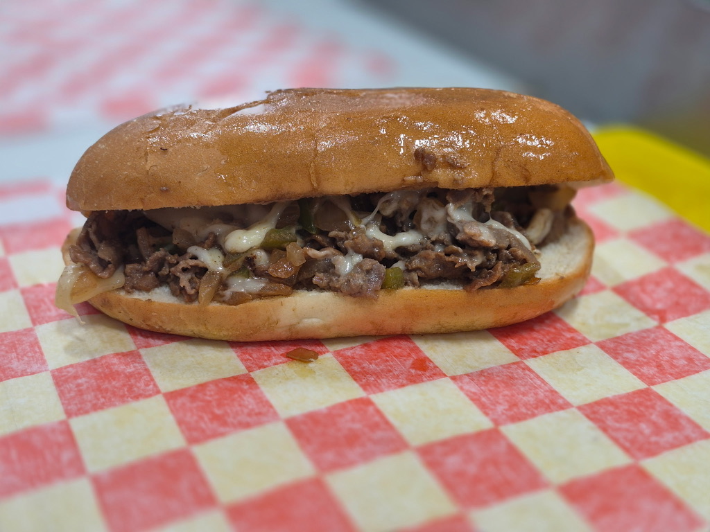 Philly cheesesteak sandwich with melted cheese on a toasted roll